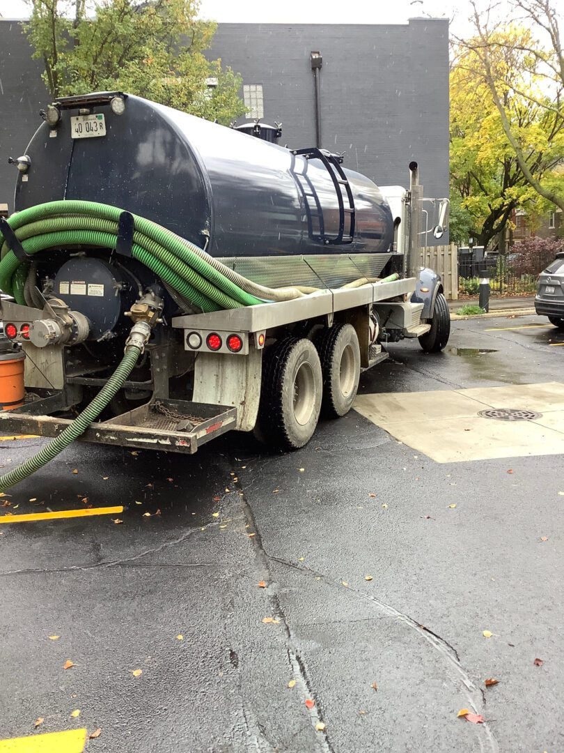 A truck with a hose attached to it is parked in the street.