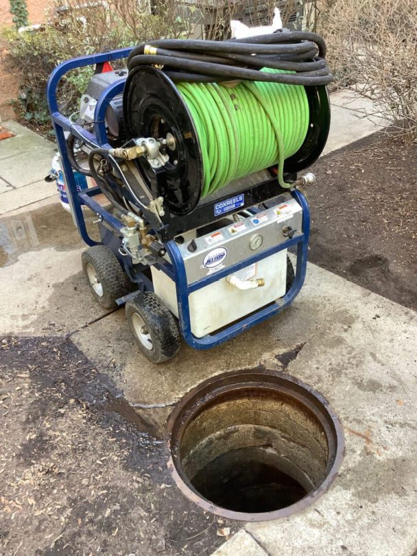 Hydrojetting machine next to an open catch basin.